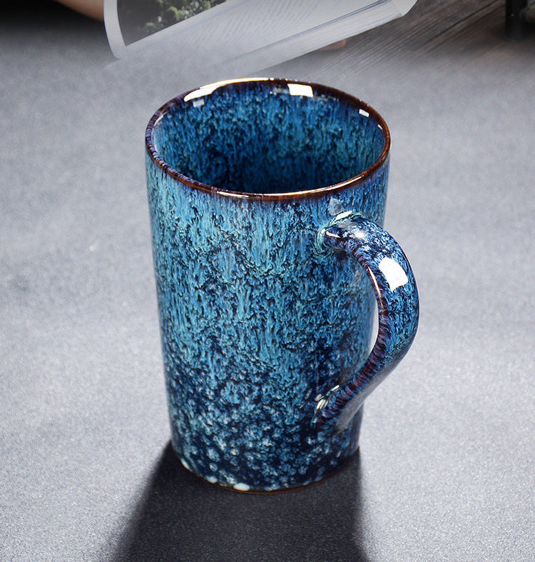 Blue ceramic mug with speckled pattern on a gray surface